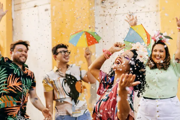 pessoas-sorrindo-jogando-confetes-e-segurando-guarda-chuvas-coloridos-no-carnaval-festa-que-deu-origem-as-marchinhas